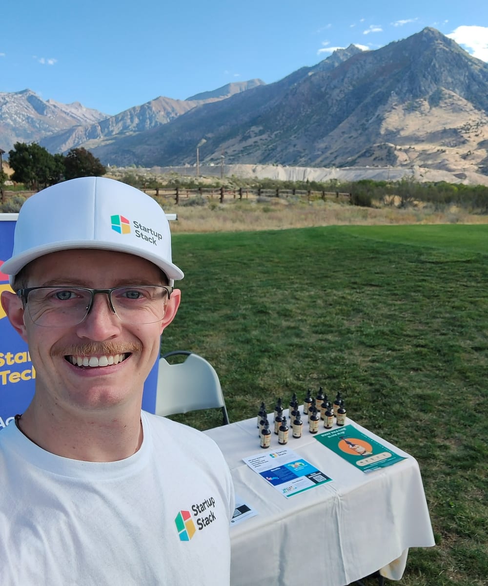 Jonathan Engle at a Startup Stack booth at an outdoor event in Utah